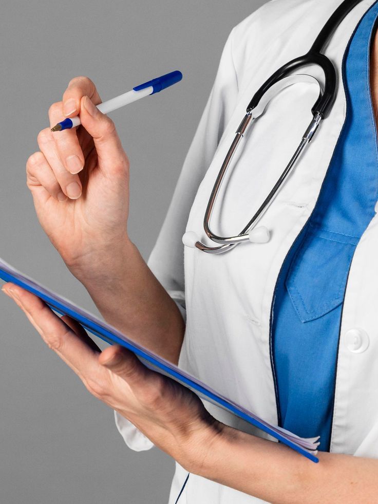 A doctor with a stethoscope holding a pen over a clipboard, ready to note down details